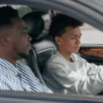 Teen driver focusing on the road with an adult supervising in the passenger seat