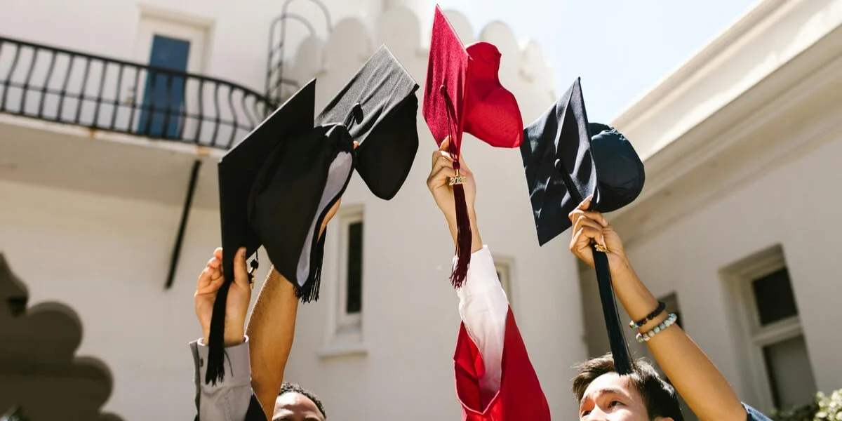 Graduates raising their caps in celebration