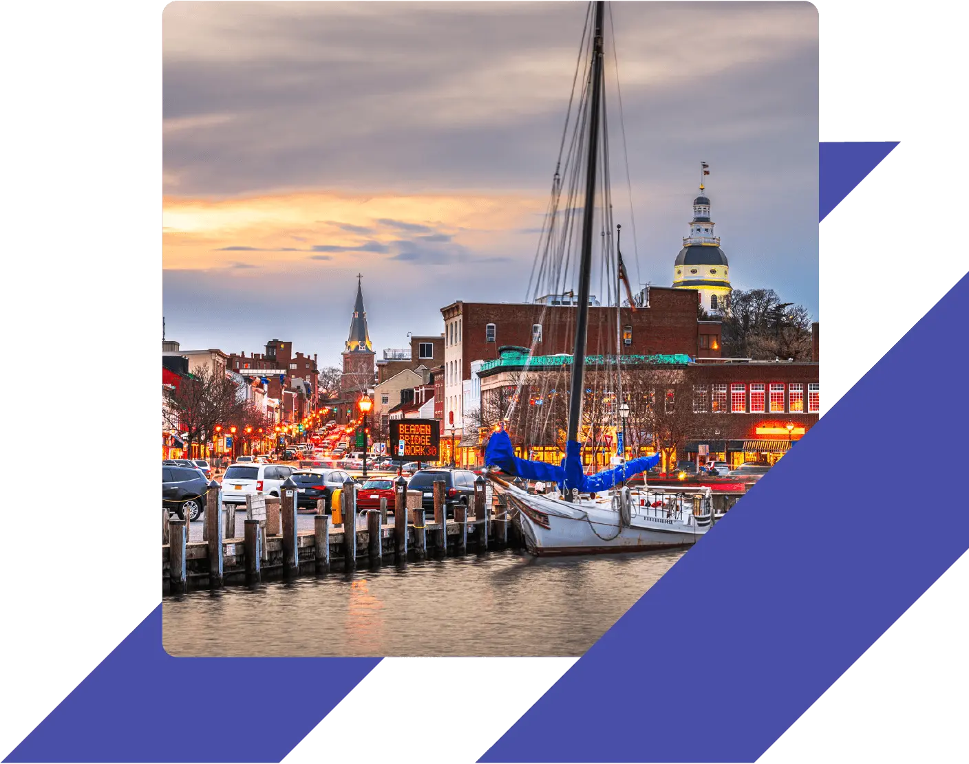 Sailboat docked at Annapolis Harbor at sunset, with downtown buildings and the Maryland State House in the background