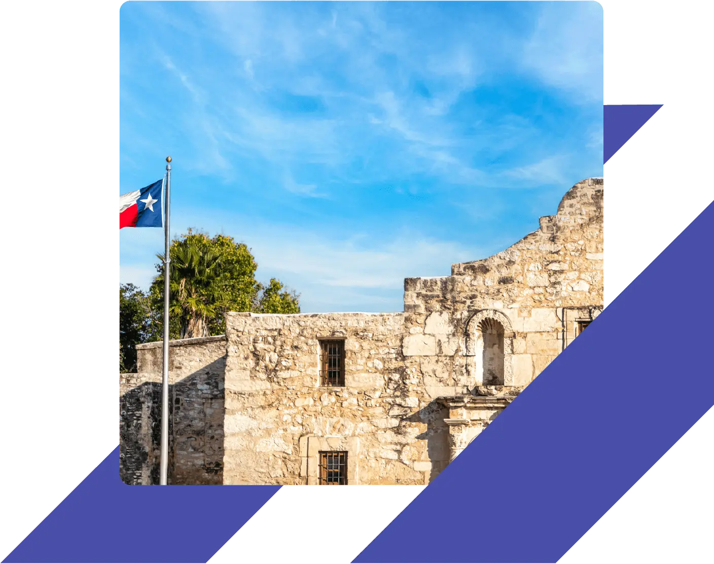 Historic Alamo Mission with Texas flag under clear skies