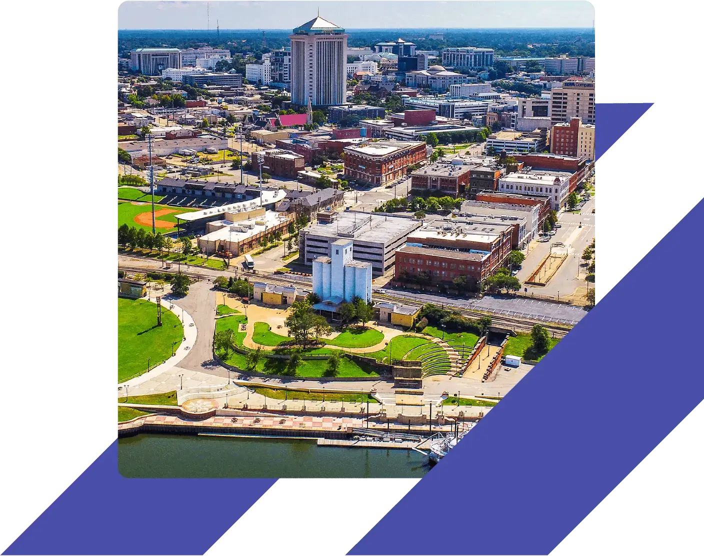 Alabama Mongomery downtown area with a tall, distinctive cylindrical-topped building, a baseball stadium, and a waterfront park with an amphitheater.