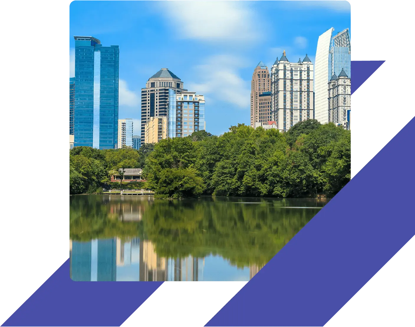 View of the Atlanta skyline from Piedmont Park, with modern high-rise buildings reflected in the lake and framed by green trees.