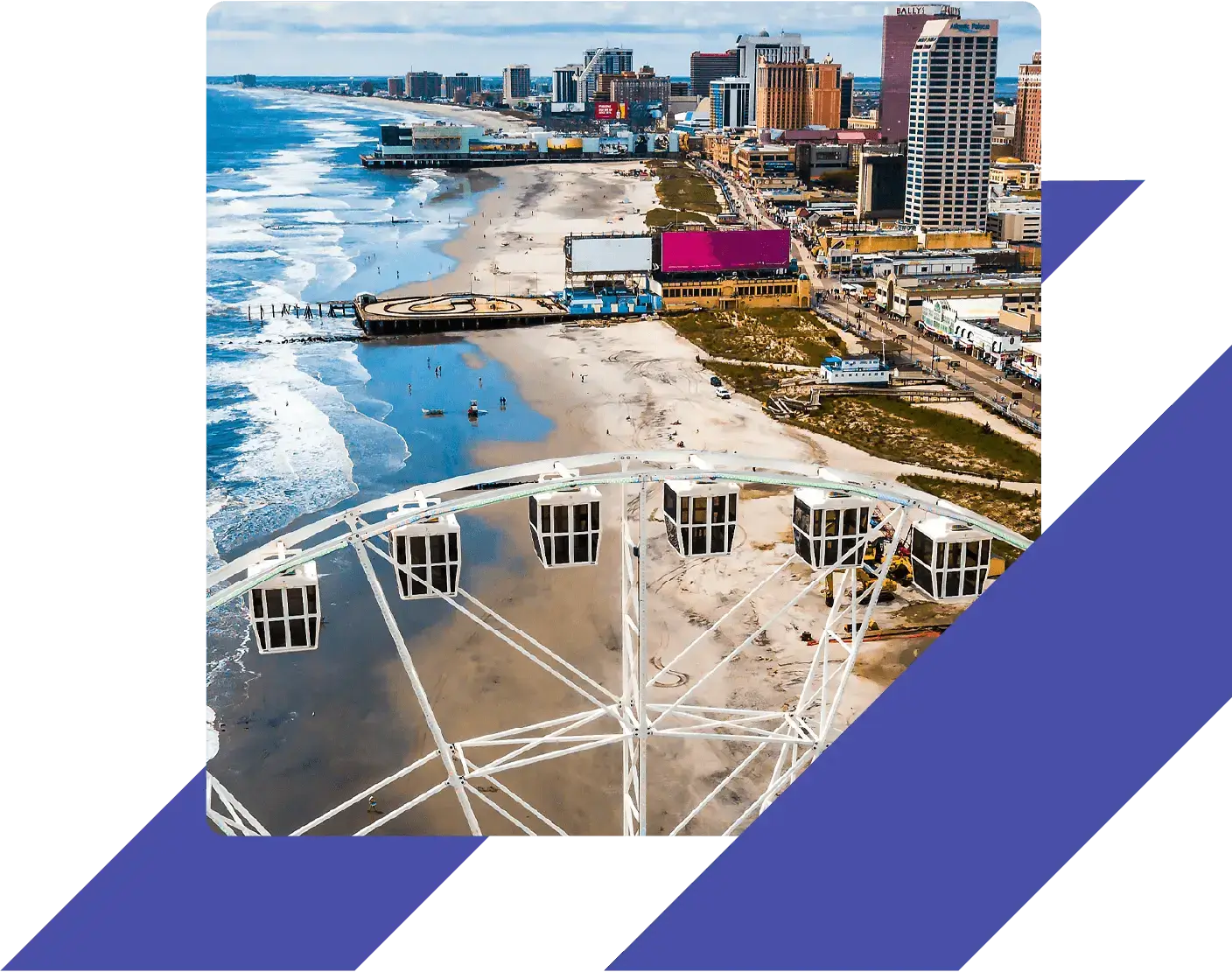View of the Atlantic City beach and boardwalk with a Ferris wheel in the foreground and casinos and hotels in the background.