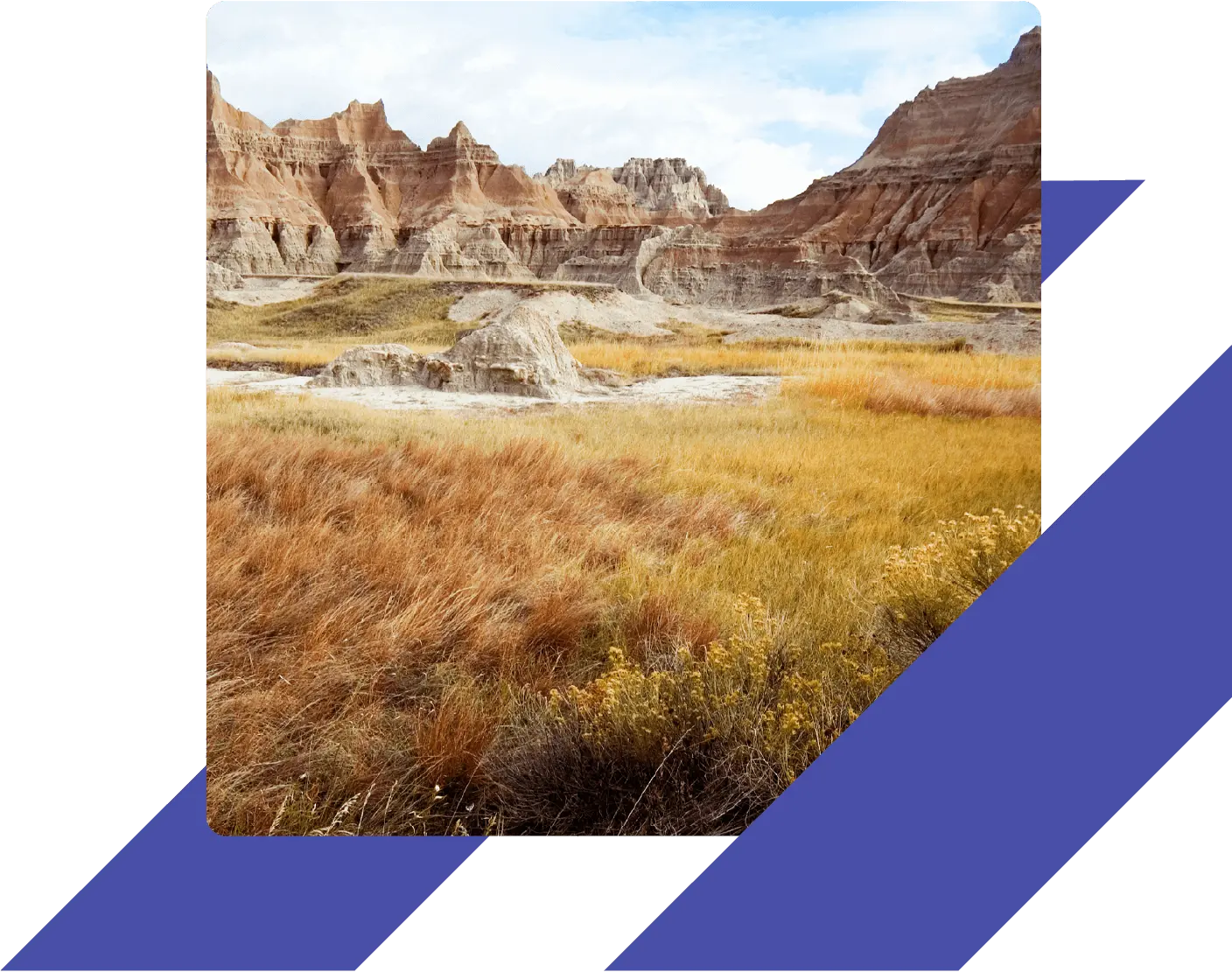 Colorful layered rock formations and golden prairie grasses in Badlands National Park, South Dakota, under a partly cloudy sky.