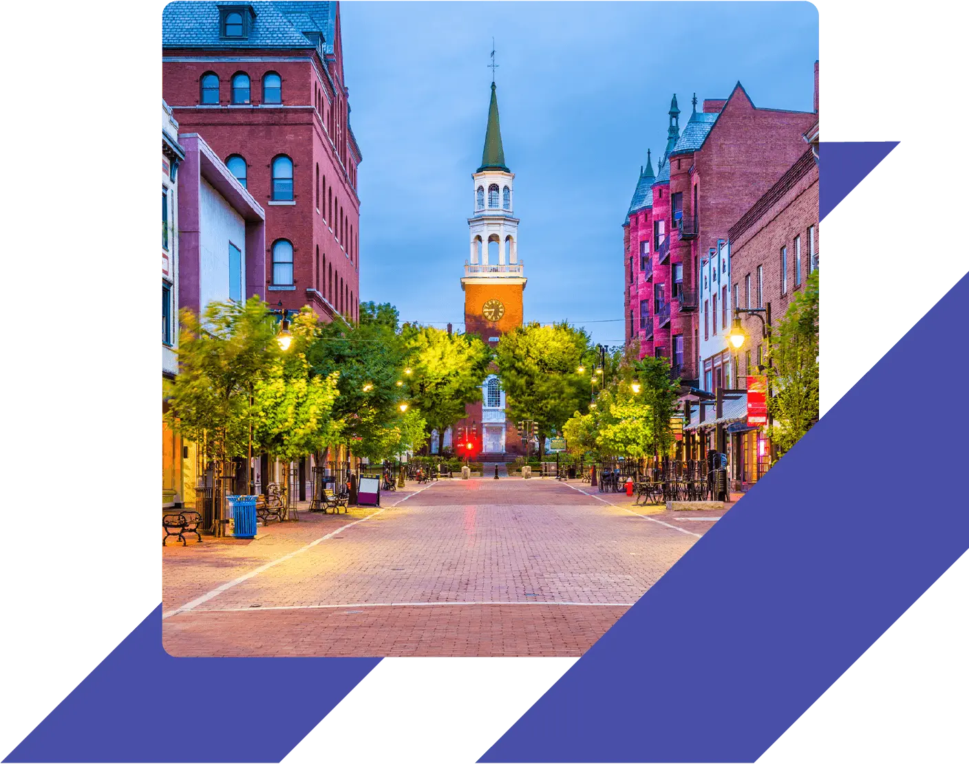 Evening view of Church Street Marketplace in Burlington, Vermont, with shops, glowing streetlights, and the steeple of the First Unitarian Universalist Church.