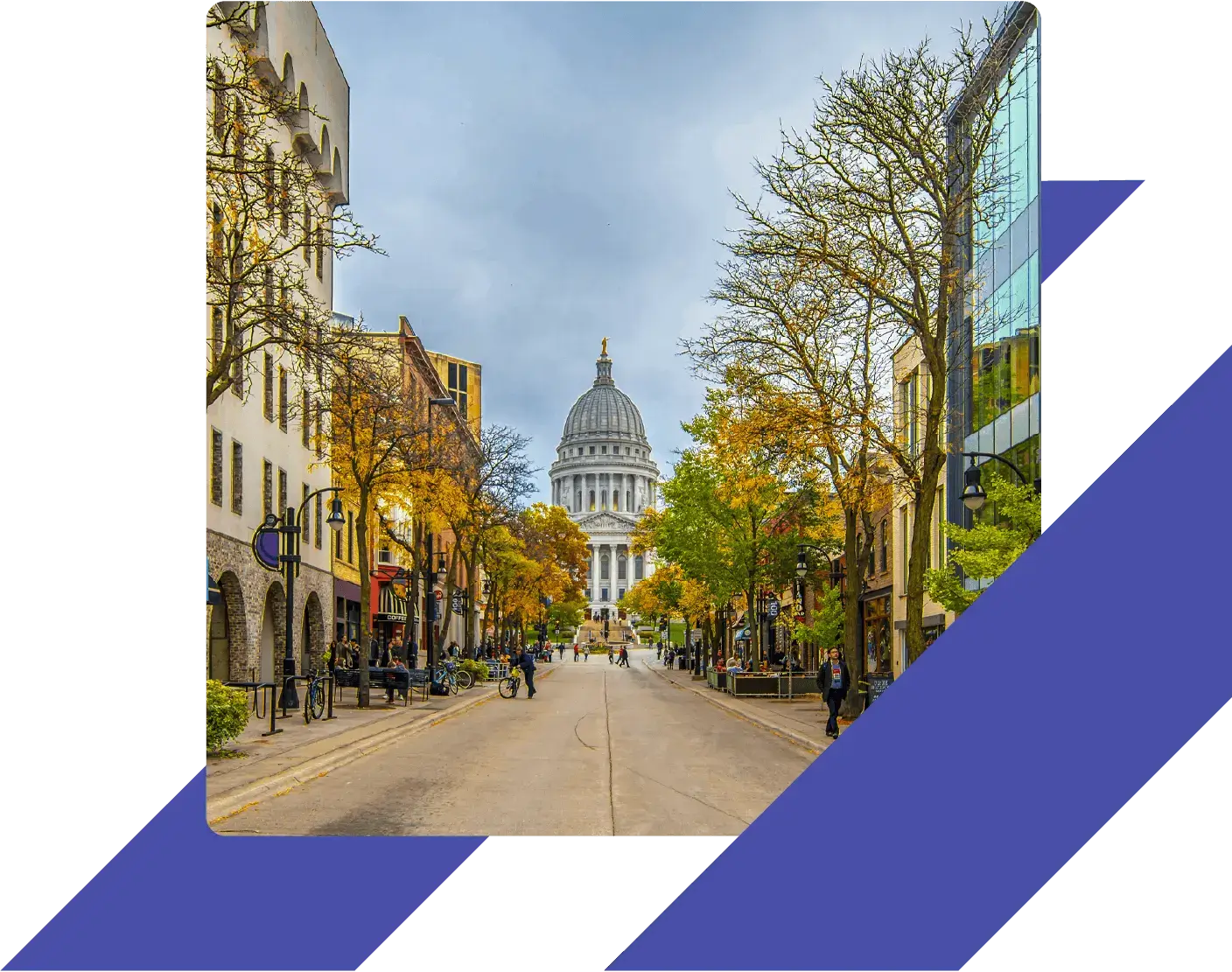 View of the Wisconsin State Capitol from State Street in Madison, with colorful autumn trees and pedestrians along the shop-lined road.