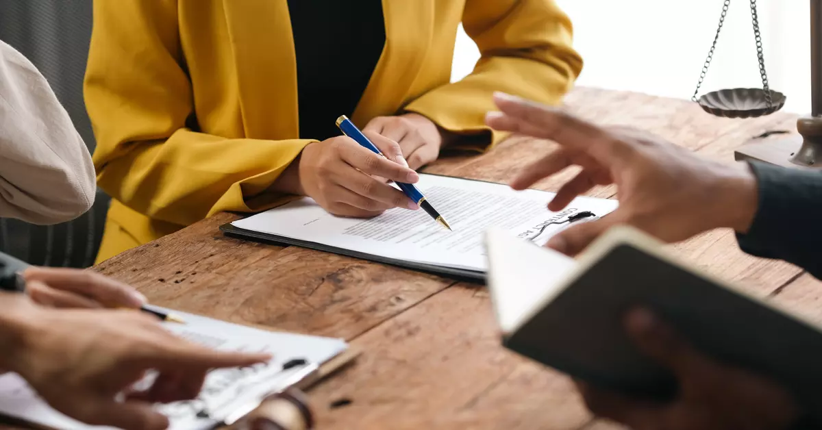 Person reviewing financial documents and writing notes.