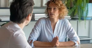 Woman talking to a man in an office.