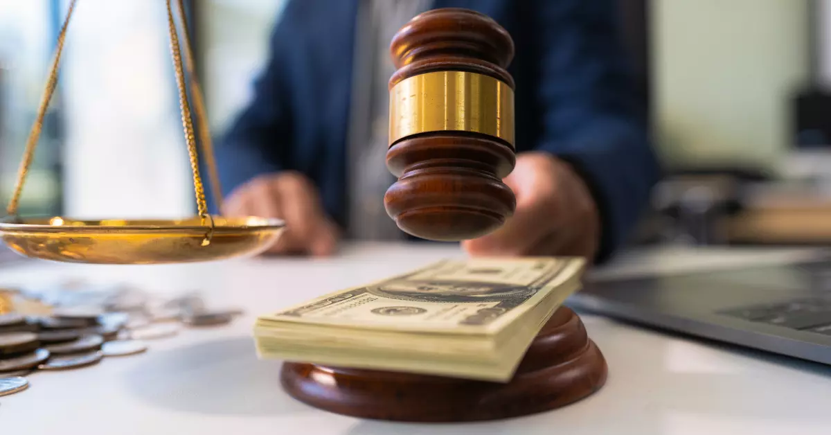 A court gavel striking down on top of some paper money.
