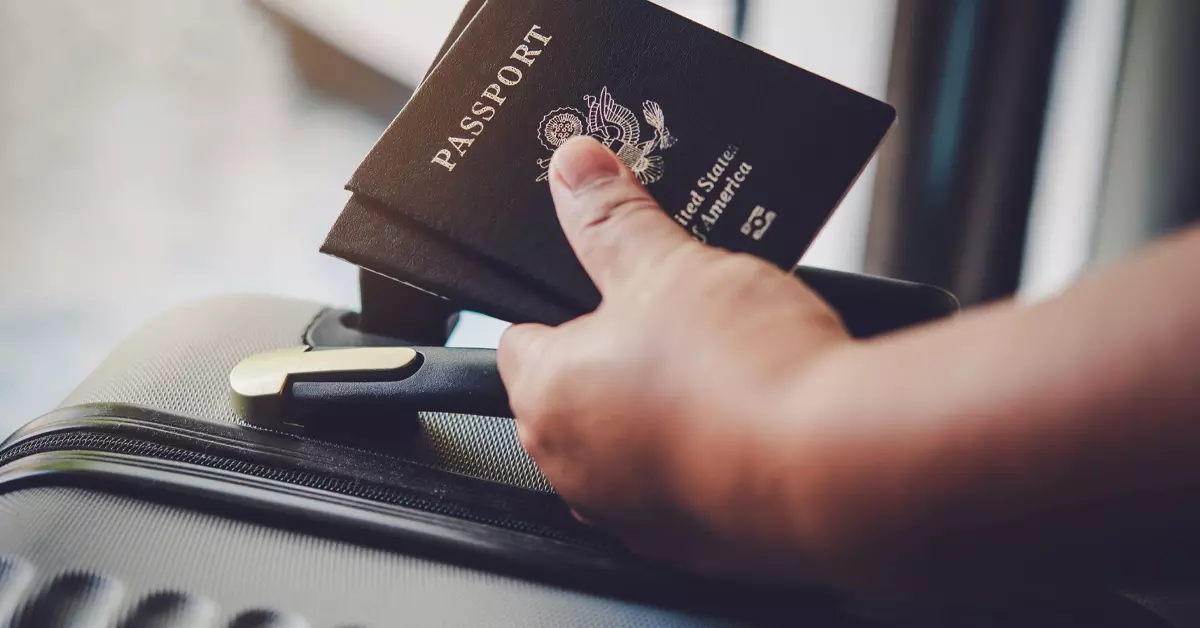 A closeup picture of a hand holding a couple of passports.