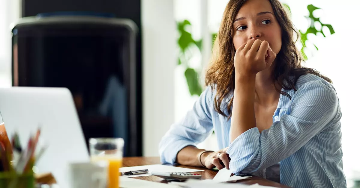 A woman sitting at the desk in deep toughts.
